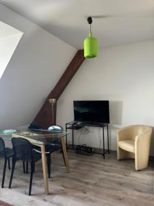 Una sala de estar con una mesa y un televisor. en Très bel appartement vues mer, en Larmor-Plage