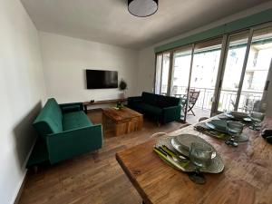 salon z zieloną kanapą i stołem w obiekcie Avocado Gandia Playa 100 m de la playa con vistas al mar para 8 personas! w mieście Puerto de Gandía