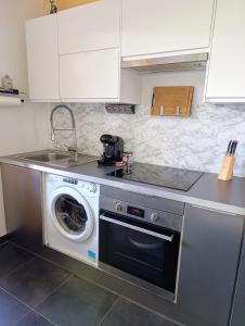 eine Küche mit einer Waschmaschine und einem Waschbecken in der Unterkunft Apartment with pool in secure residence in Nizza