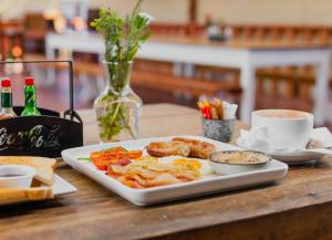 a plate of breakfast food on a wooden table at Emerald Vale Ale Cottage in Lone Tree