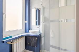 a blue bathroom with a sink and a shower at Blu Marina Alassio in Alassio