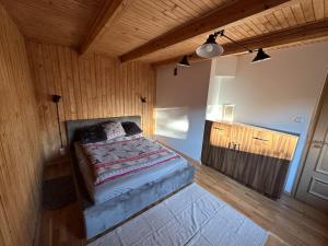 a bedroom with a bed in a room with wooden walls at Gorczańska Chata Lubomierz in Lubomierz