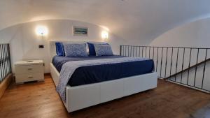 a bedroom with a bed with blue blankets and pillows at L'Ancorotto Azzurro in Gaeta