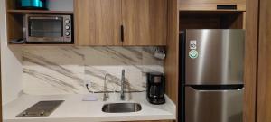 a kitchen with a stainless steel refrigerator and a sink at Beachfront Harbor 171 Condo Ocean View Pool, Gym WiFi in Puerto Vallarta
