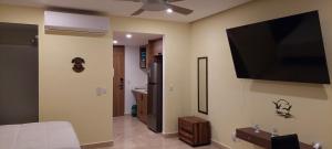 a living room with a flat screen tv on the wall at Beachfront Harbor 171 Condo Ocean View Pool, Gym WiFi in Puerto Vallarta