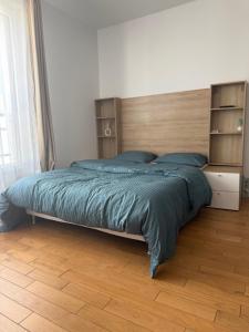 a bedroom with a large bed with a wooden headboard at La chatillonnaise in Châtillon