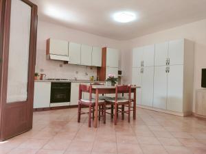 a kitchen with white cabinets and a table and chairs at Casa Giuliana in Pula