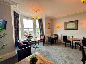 a living room with tables and chairs and a window at The Rockside in Scarborough