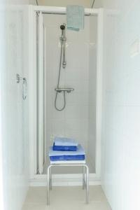 a shower with blue towels on a table in a bathroom at Maison Studios & Appartements Les 4 Vents in Luc-sur-Mer