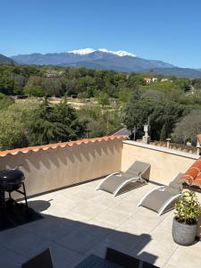 a patio with two chairs and a view of mountains at Panorama du Vallespir in Maureillas