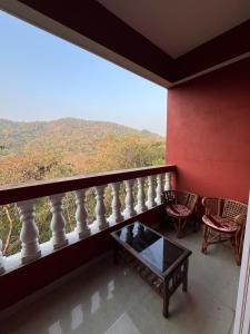 a room with a balcony with a table and chairs at Surreal Mountain View Studio in Canacona