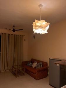 a living room with a couch and a chandelier at Surreal Mountain View Studio in Canacona