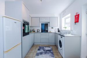 Hough GreenにあるBeautiful 3Bed Home In Chester, Games Room, Smart TV, Long Term Discのキッチン(白いキャビネット、洗濯機、乾燥機付)