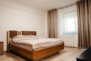 a bedroom with a large bed and a window at Don apartaments in Tîrgu Neamţ