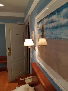 una habitación con dos lámparas y un cuadro en la pared en Hotel Faro de San Vicente, en San Vicente de la Barquera