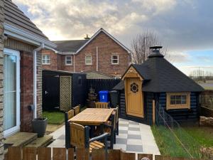 a backyard with a wooden table and a house at Atlantic Bliss in Portstewart