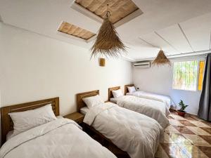 three beds in a room with white sheets at Dar Surfana Morocco in Aourir +23 photos