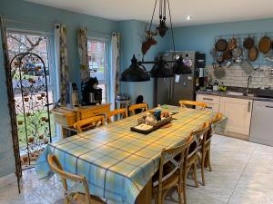 a kitchen with a table with chairs and a refrigerator at Atlantic Bliss in Portstewart