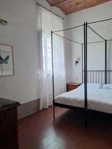a bedroom with a four poster bed and a window at Agriturismo Il Pozzo in Greve in Chianti
