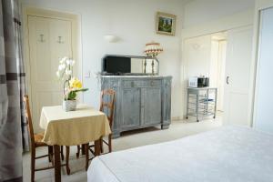 a bedroom with a table and a television in a room at Maison Studios & Appartements Les 4 Vents in Luc-sur-Mer