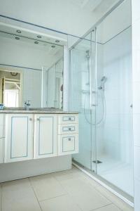 a bathroom with a shower and a sink at Maison Studios & Appartements Les 4 Vents in Luc-sur-Mer