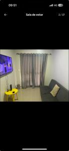 a room with a couch and a table and a tv at Apartamento próximo agrishow 1 in Ribeirão Preto