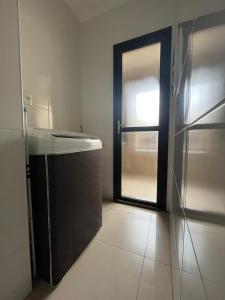 an empty kitchen with a refrigerator and a door at Apartamento próximo agrishow 1 in Ribeirão Preto +1 photo