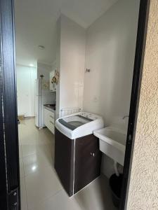 a white bathroom with a sink and a tub at Apartamento próximo agrishow 1 in Ribeirão Preto