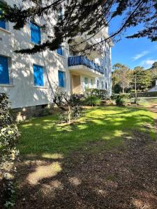 ein großes weißes Gebäude mit einem Rasenplatz in der Unterkunft Le Petit Paradis By Tranquil At Home in Pornichet
