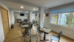 a waiting room with tables and chairs in a building at Hostal O Pincho in Ponte Do Porto