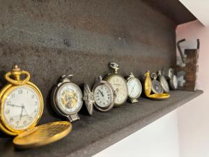 a row of different types of clocks on a shelf at Itaca Porto Loft& Rooms in Milazzo