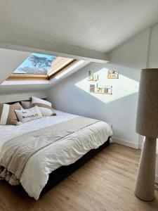 ein Schlafzimmer mit einem Bett und zwei Dachfenstern in der Unterkunft Le Petit Paradis By Tranquil At Home in Pornichet