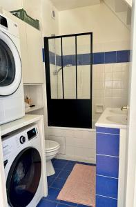 ein Badezimmer mit Waschmaschine und Toilette in der Unterkunft Le Petit Paradis By Tranquil At Home in Pornichet