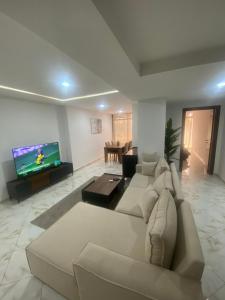 a living room with a couch and a flat screen tv at Appartement haut standing in Matriouene