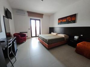 a bedroom with a bed and a red chair at Rooms affittacamere in Lioni
