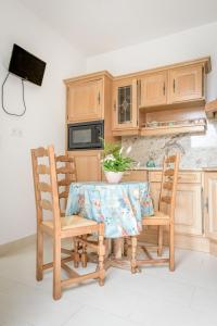 a kitchen with a wooden table and two chairs at Maison Studios & Appartements Les 4 Vents in Luc-sur-Mer