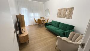 a living room with a green couch and a table at Vivienda Quina in Laxe