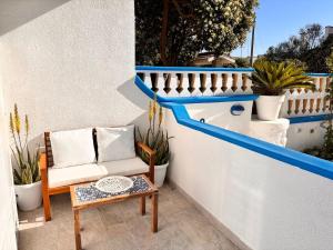 a chair and a table on a balcony with plants at Villa Ranieri-Casa con vista a Campo di mare in Torre San Gennaro