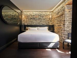 ein Schlafzimmer mit einem Bett und einer Ziegelwand in der Unterkunft Hôtel Maison du Fort in Québec