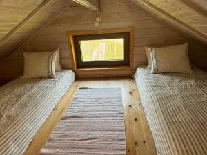 two beds in a room with a window at Laasi Cozy Cottage in Kaigutsi