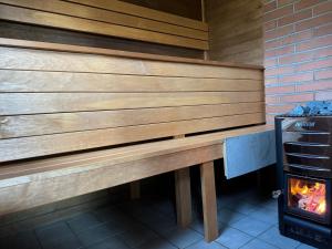 a wooden bench in a kitchen with a stove at Laasi Cozy Cottage in Kaigutsi