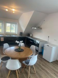 a kitchen with a table and chairs and a refrigerator at Penzion U Jandů in Běhařov