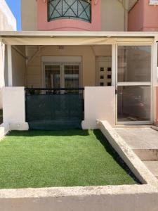 a house with a yard of green grass in front of it at Unique Apartment in Alexandroupoli