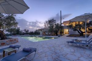 a swimming pool with two chairs and an umbrella at Ethos Retreat, Luxury Villas in Areopoli