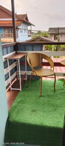 een stoel en een tafel op een balkon met groen gras bij Din others roomstay in Kuala Terengganu