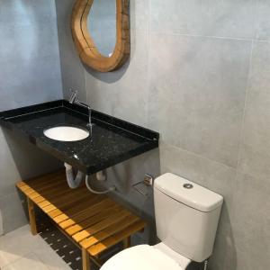 a bathroom with a sink and a toilet and a mirror at Casa Vento Parte Baixa in Luis Correia +15 photos