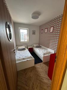 two beds in a room with a door open at Apartament Eliza in Ustroń