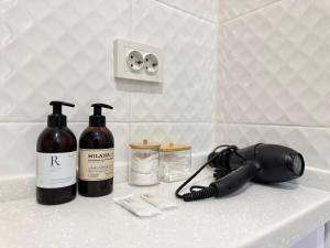 eine Badezimmertheke mit zwei Flaschen Wein und einem Telefon in der Unterkunft Новая квартира рядом с ЭКСПО АЭРОПОРТОМ ПРЕЗИДЕНТСКАЯ БОЛЬНИЦА Венский 29б in Astana + 1 Foto