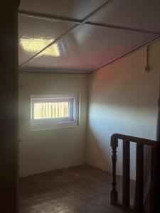 an empty room with a window and a staircase at nani house the mall in Shimla