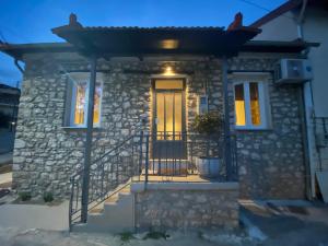 a stone house with a front door with a gate at VIDO Stone House in Kalavrita